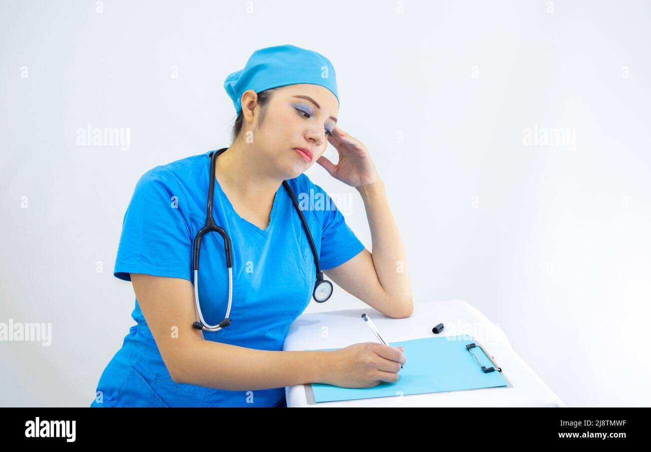 Schöne Frau Labortechnikerin trägt einheitliche und blaue OP-Kappe, die Ergebnisse analysiert, auf weißem Hintergrund Stockfoto