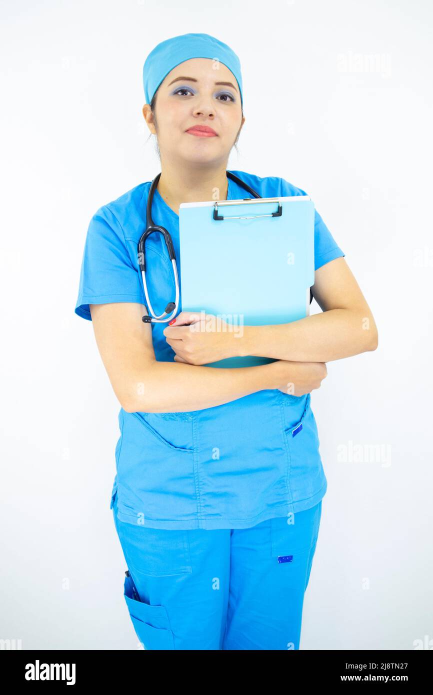 Schöne medizinische Frau, trägt Uniform und blaue OP-Kappe, Stethoskop am Hals, hält Zwischenablage mit Ergebnissen, auf weißem Hintergrund Stockfoto