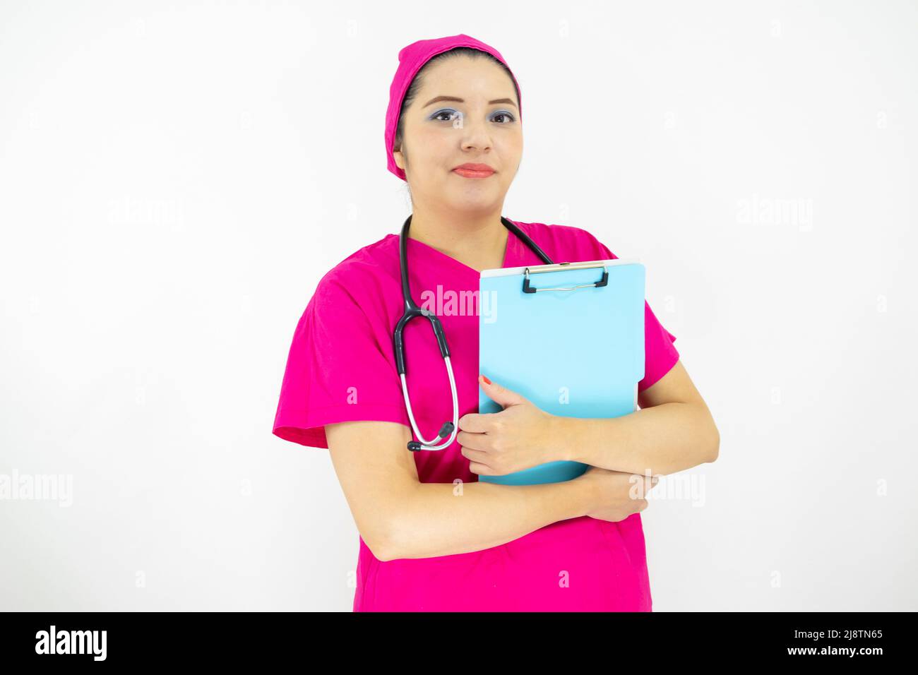 Schöne Frau medizinische Assistentin, trägt Uniform und rosa OP-Kappe, Stethoskop am Hals, hält Zwischenablage mit Ergebnissen, auf weißem Hintergrund Stockfoto