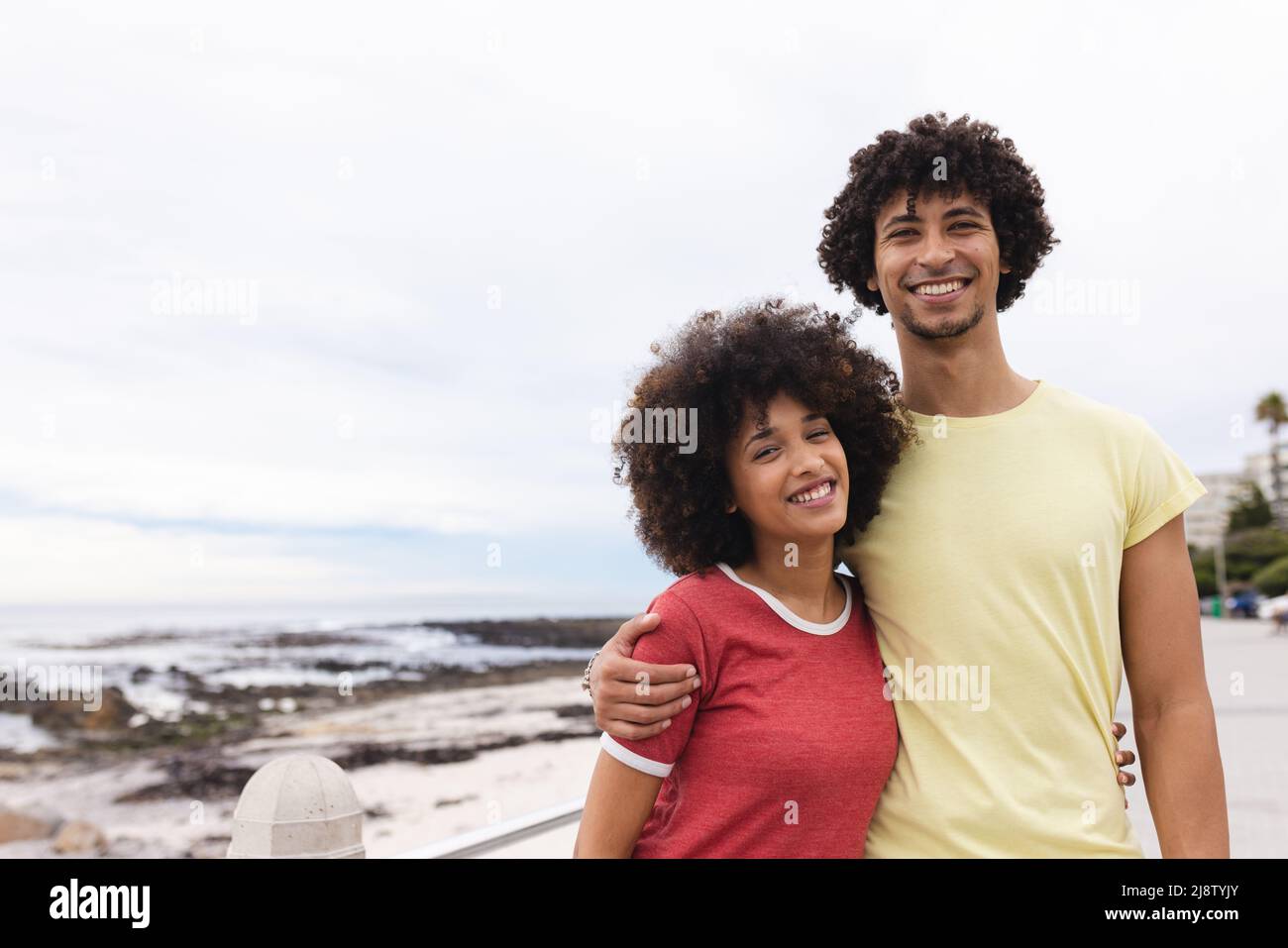 Porträt eines jungen afro-afroamerikanischen Paares, das am Strand am Himmel lächelt, Kopierraum Stockfoto