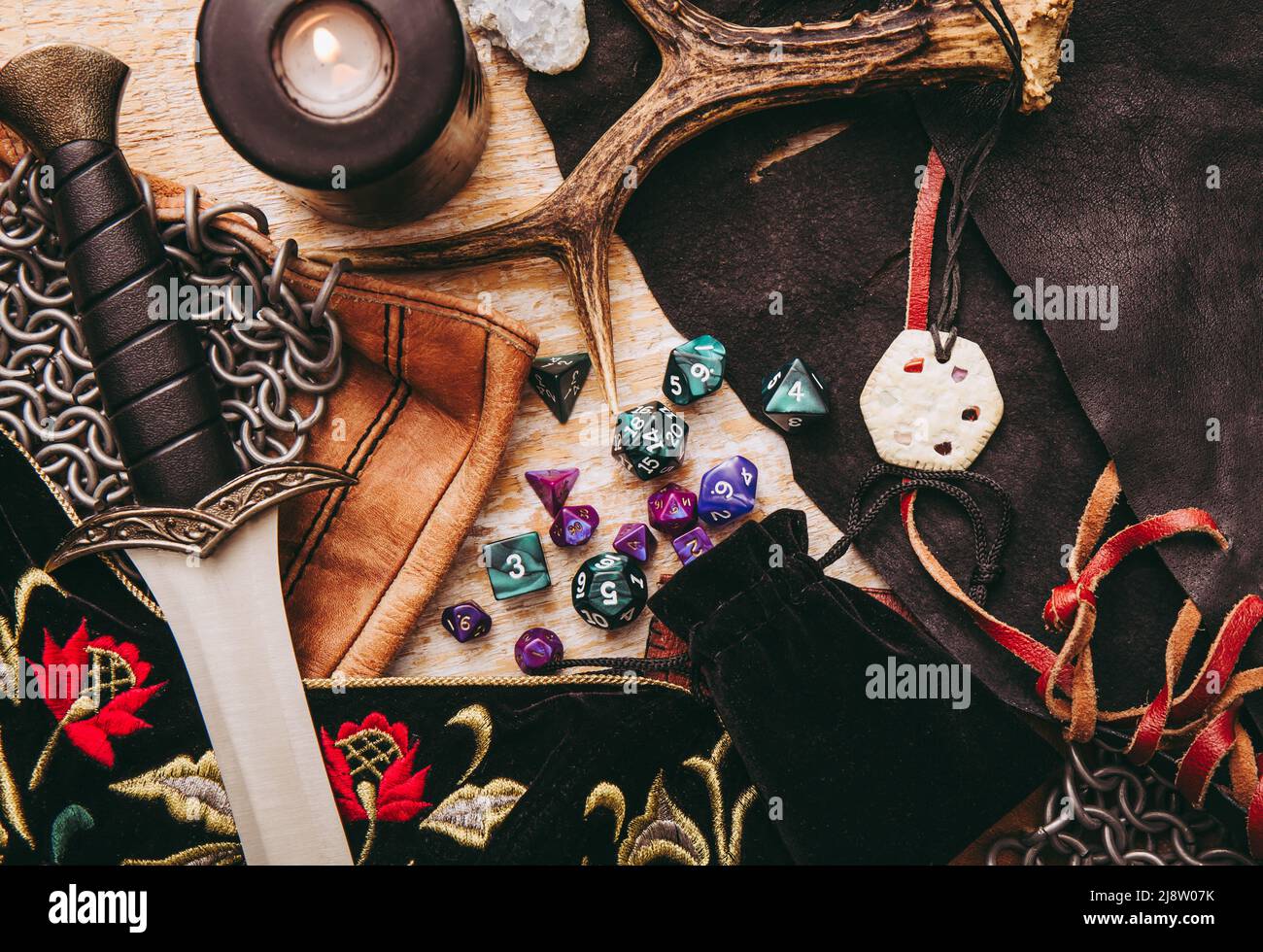 Fantasy Rollenspiel Brettspiel Stillleben Konzept. Hintergrund mit verschiedenen Charakter-Objekte Werkzeuge dekoriert. Dolch, Kettenpost, Amulett, Kleidung, Würfel Stockfoto