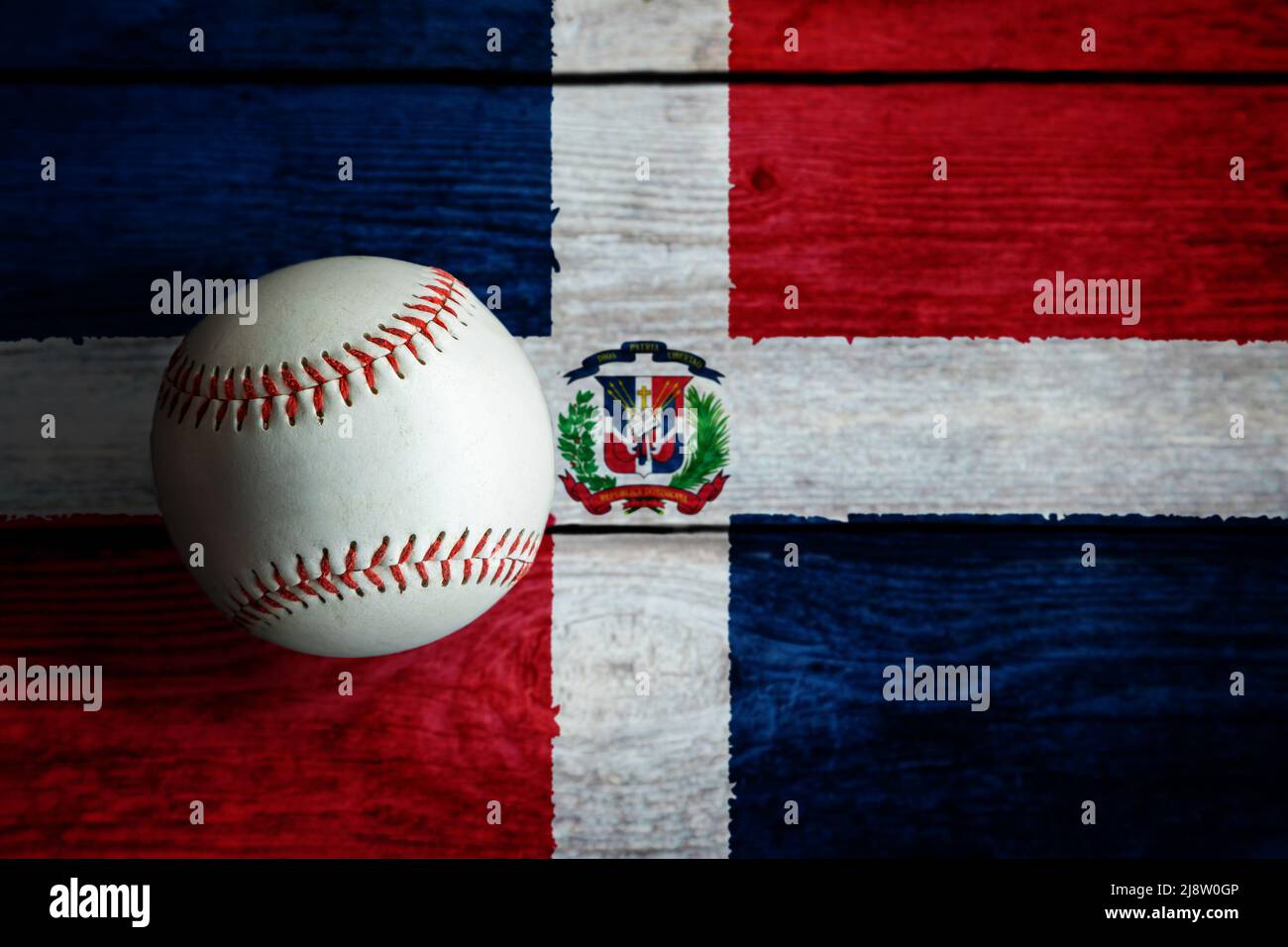 Leder-Baseballspiel auf rustikalem Holzhintergrund mit Dominikanische Republik Flagge mit Kopierraum bemalt. Die Dominikanische Republik gehört zu den besten Baseballspielen Stockfoto