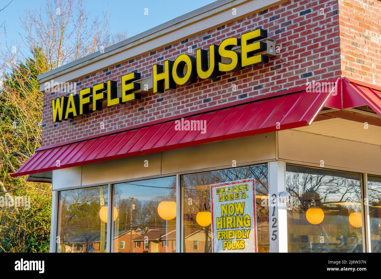 Außenwerbung, Markenwerbung und Logo für das zwanglose Restaurant „Waffle House“ in Gelb, Blockbuchstaben über roter Markise und Glasfenstern. Stockfoto