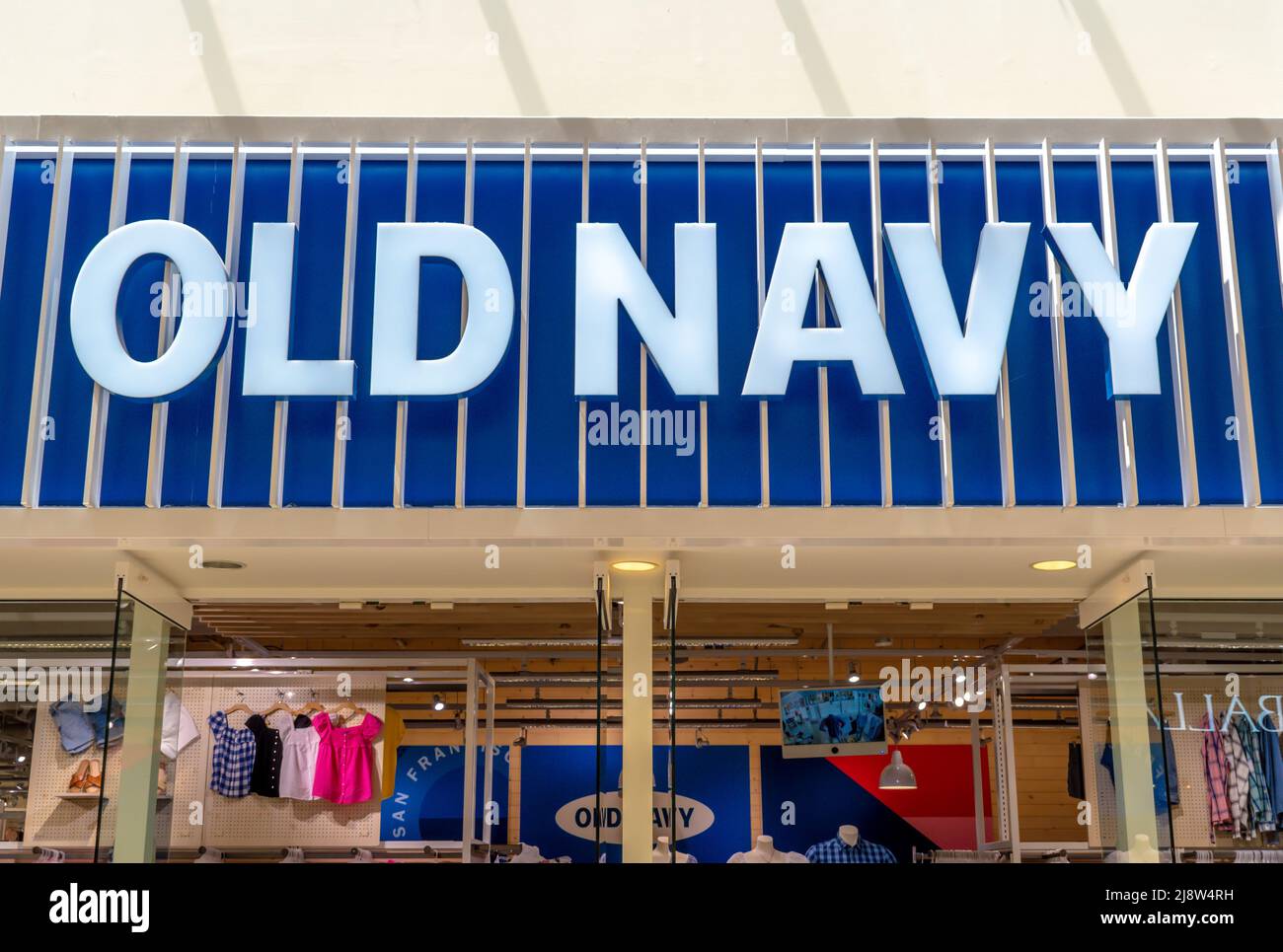 „Old Navy“-Inneneinkaufsstraße mit Marken- und Logo-Schildern in Blau und Weiß über reflektierenden Glasfenstern in der Southpark Mall in Charlotte, NC. Stockfoto