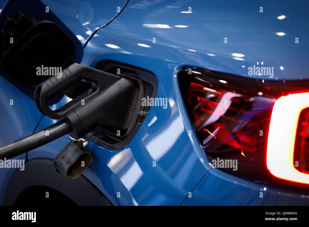 Ladeenergie eines blauen Elektroautos. Ladeleistung für Elektrofahrzeug-Elektroauto, Nahaufnahme. Stockfoto