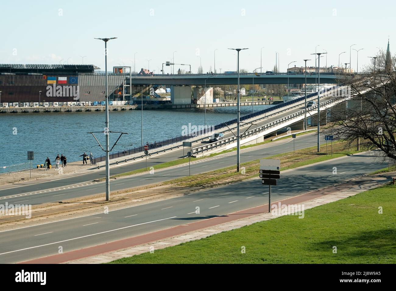 Blick von oben auf den Stadtverkehr an einer Kreuzung. Luftaufnahme der Kreuzung mit Brücke über den Kanal von oben, Autoverkehr. Autos fahren über die br Stockfoto