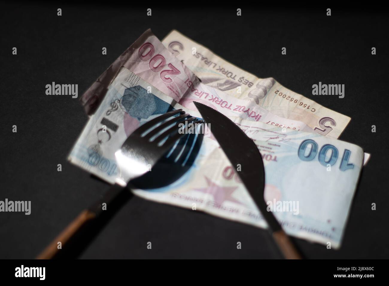 Banknoten mit Besteck essen Stockfoto