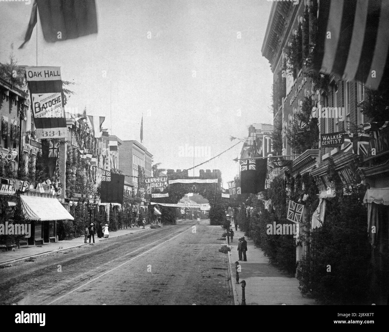 Front Street, Belleville, Ontario, Blick nördlich von Campbell Street. Die Gebäude auf der Straße sind mit Unionsflaggen und Evergreens geschmückt, um heimisch Männer willkommen zu heißen, die in der Nordwestaufstand bei der Schlacht von Batoche Ca gedient haben. 1885 Stockfoto