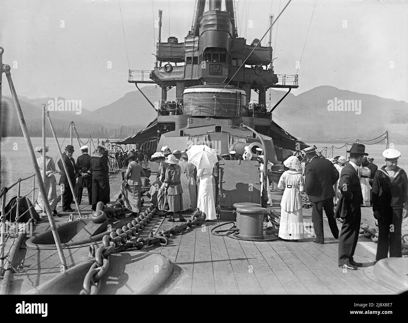 Besucher auf dem Vordeck auf der HMS New Zealand in Vancouver. 12-Zoll-Geschützturm ist sichtbar, hinter dem 4-Zoll-Geschütze sind sichtbar montiert in Überbau Ca. 1913 Stockfoto