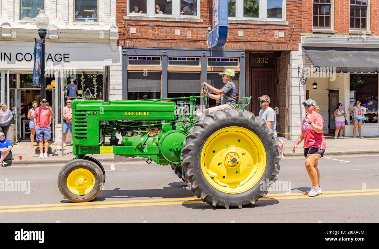 Travis und Gina Vaughns junger Sohn, der einen alten John Deere Traktor fährt Stockfoto