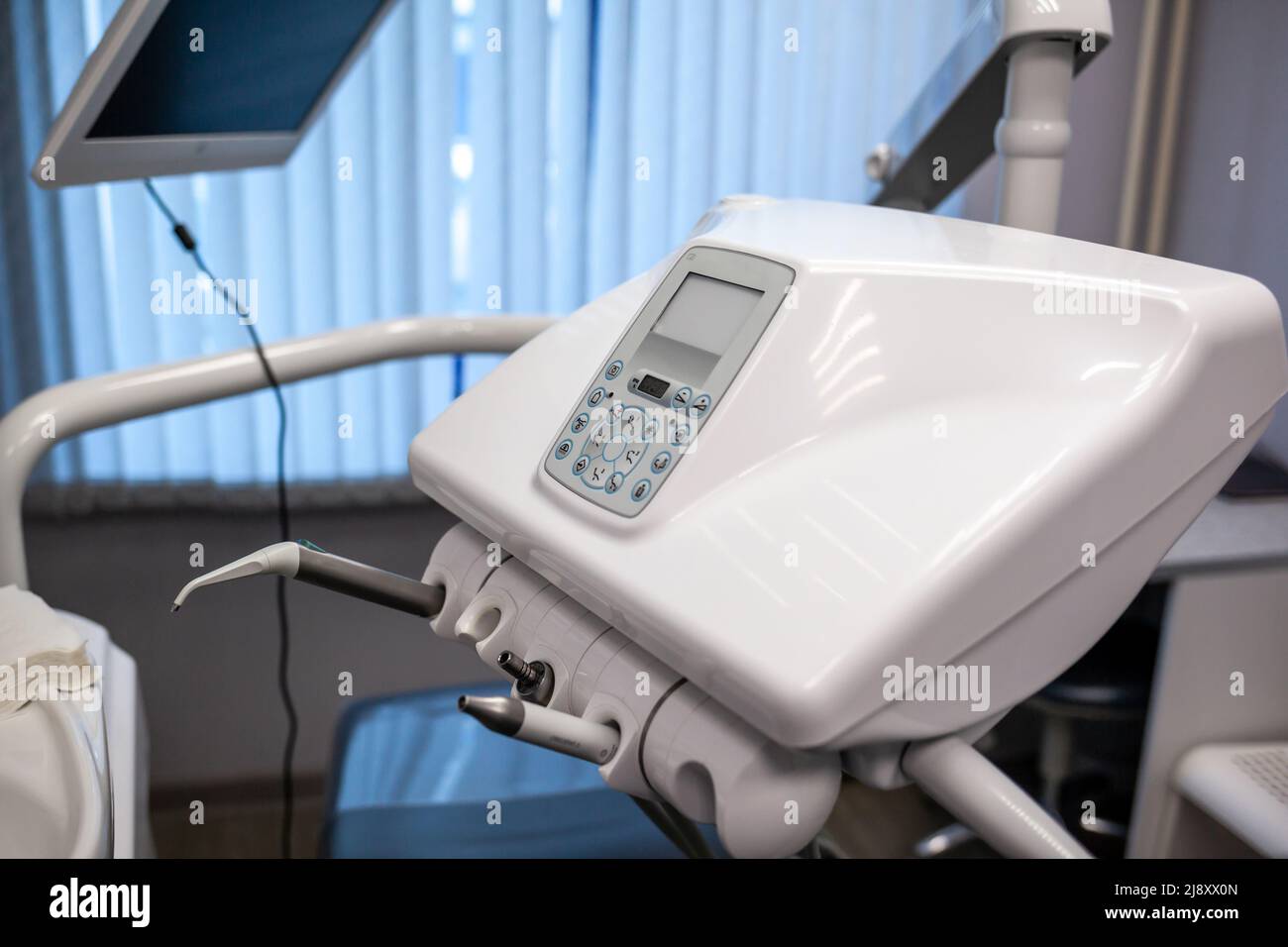 Dental Innenbüro mit moderner Ausstattung. Moderne Zahnarztpraxis. Zahnarztstuhl und anderes Zubehör von Zahnärzten in blau, Sanitäter Licht verwendet Stockfoto