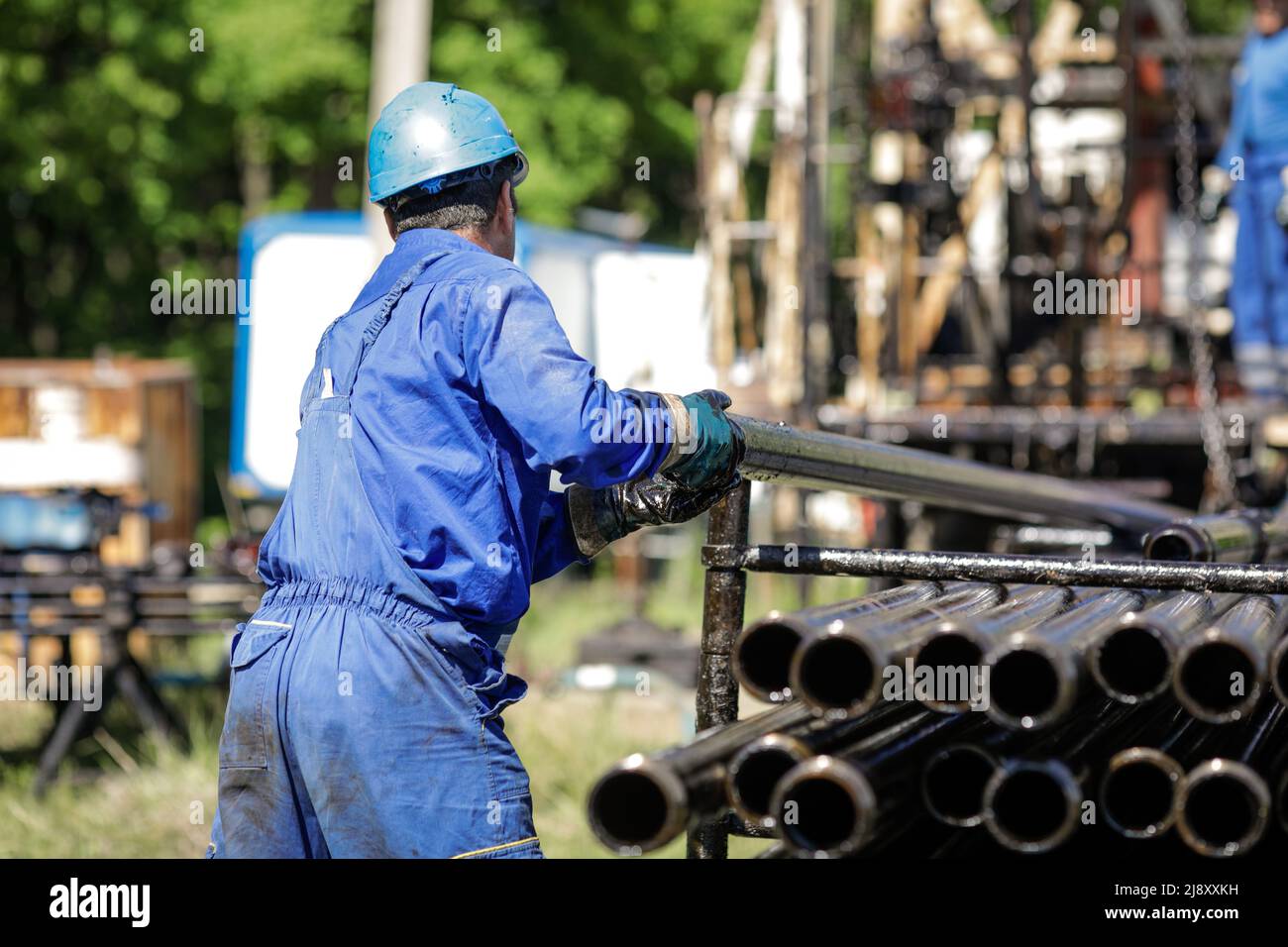 Mitarbeiter der Öl- und Gasindustrie betreibt Bohrrohre für Bohrinseln auf einer Bohrinsel. Stockfoto