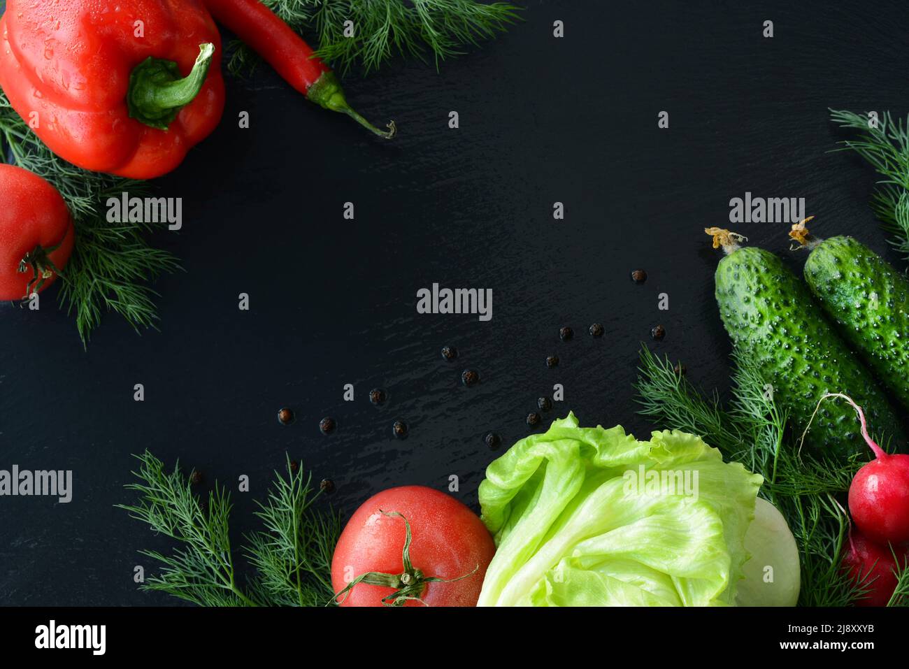 Tomaten Gurken roter Paprika Paprika Radieschen Dill Eisbergsalat, schwarzer Hintergrund, Kopierraum Stockfoto