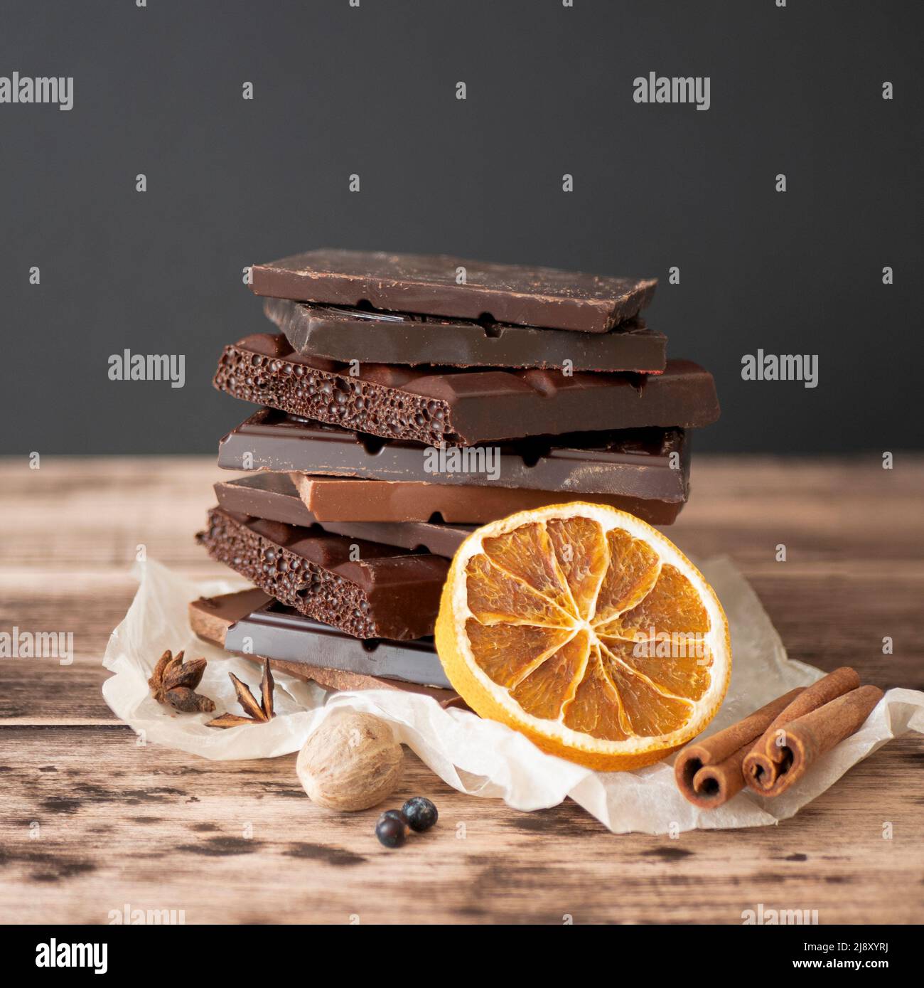 Verschiedene Schokoladenstückchen mit Gewürzen, selektiver Fokus. Konzept der süßen Speisen, quadratisches Format Stockfoto