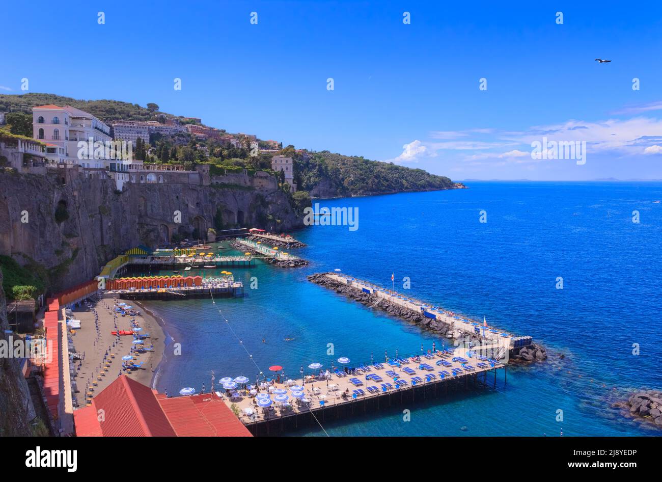 Sommer: Sorrento Strand in Italien. Blick auf die mit Strandhütten und Sonnenschirmen gesäumten Stege am Meer. Stockfoto