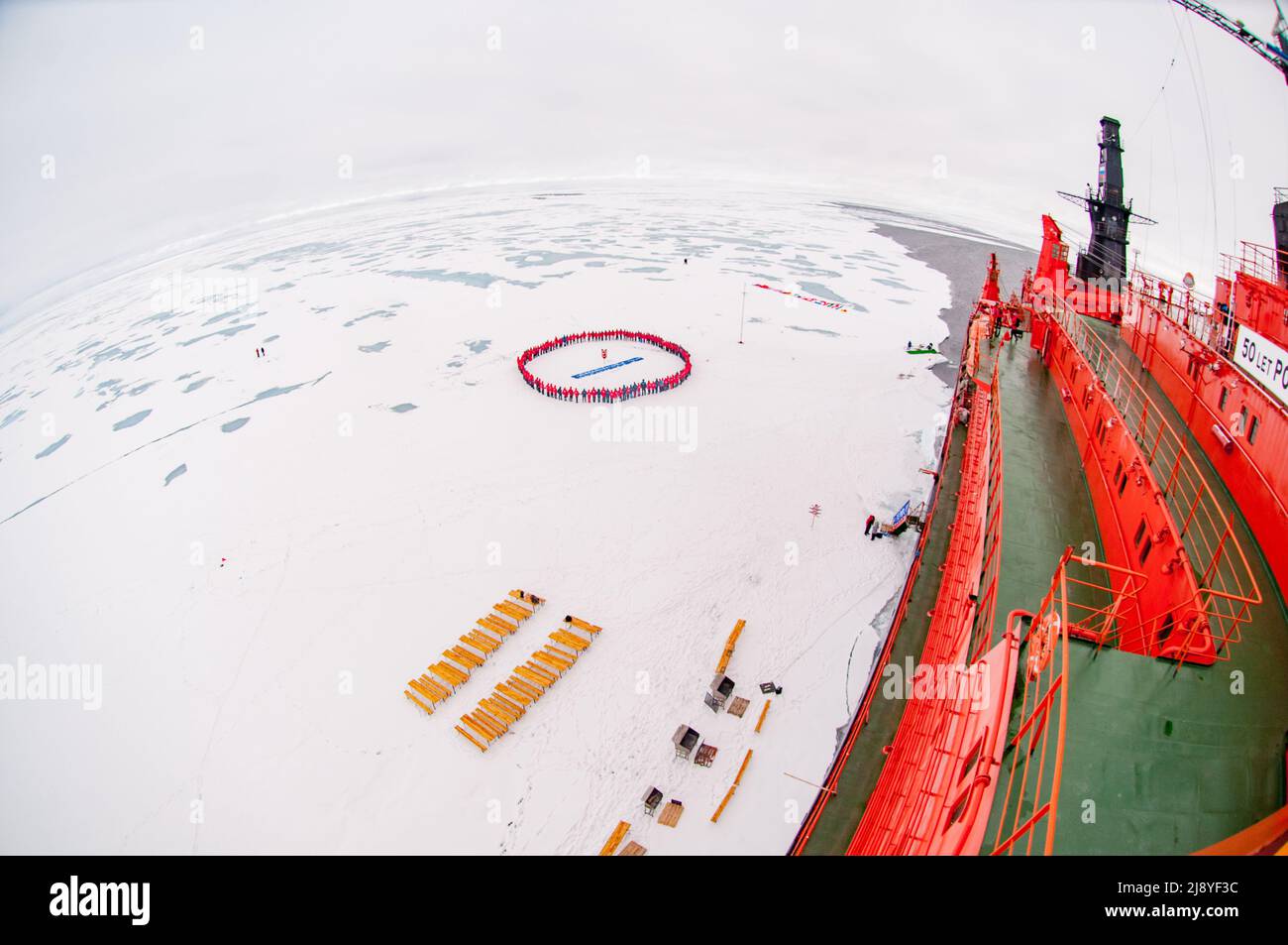 Touristen bilden am geografischen Nordpol einen Kreis, um ihre Ankunft zusammen mit dem 50-jährigen nuklearen Eisbrecher des Sieges (50 Let Pobedy) zu feiern Stockfoto