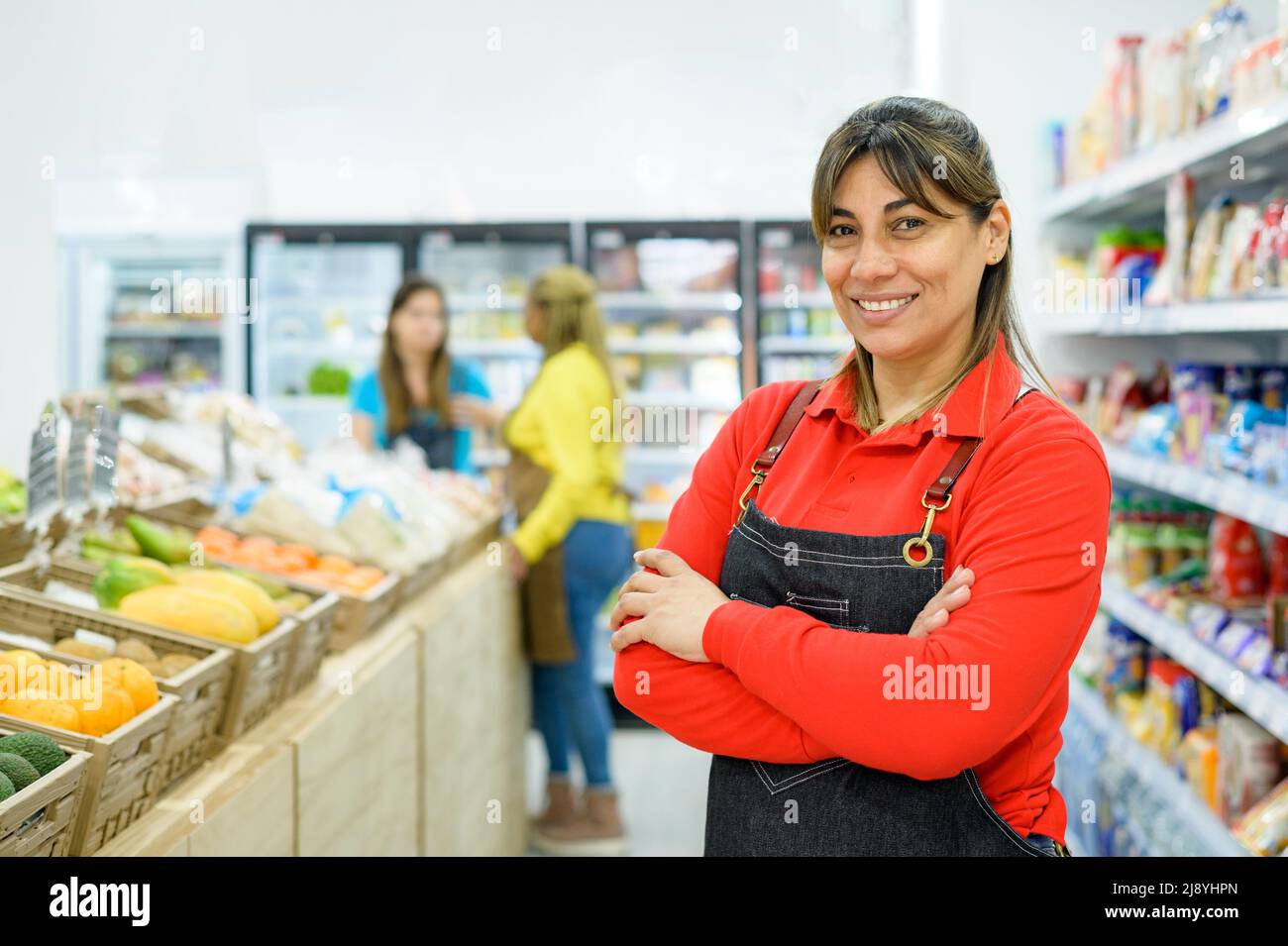 Positiver hispanischer Verkäufer im Supermarkt Stockfoto