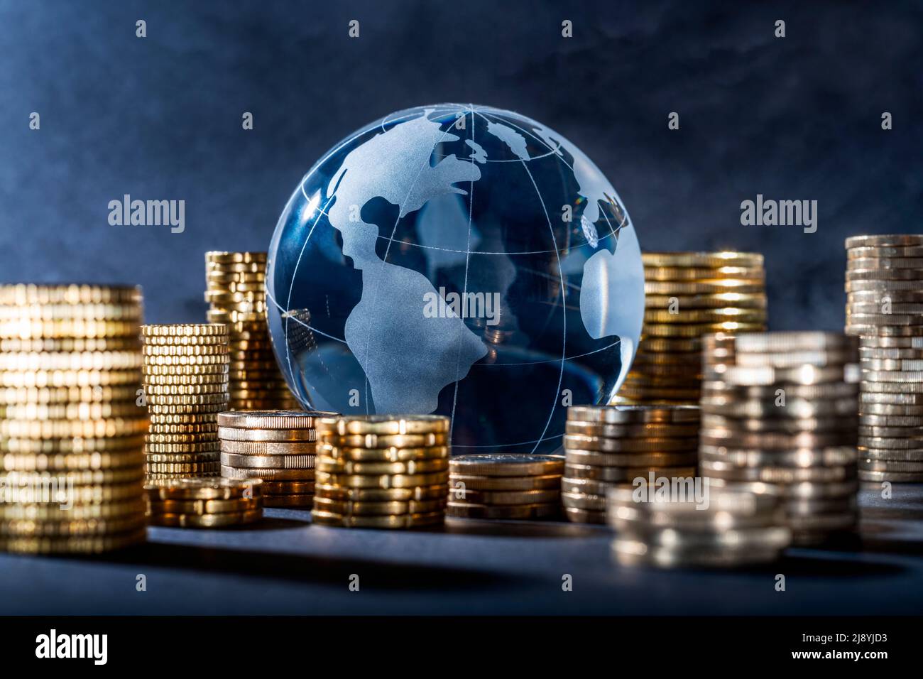 Globe und Stapel mit Münzen. Geld lässt die Welt umrunden Stockfoto