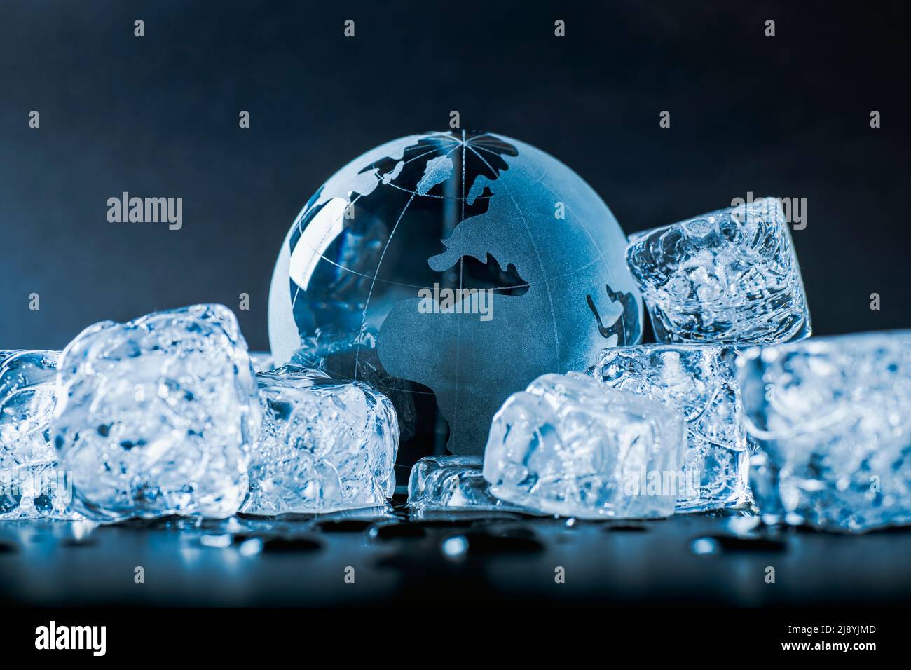 Der Globus ist von Eiswürfeln umgeben, die eine neue geologische oder politische Eiszeit symbolisieren Stockfoto