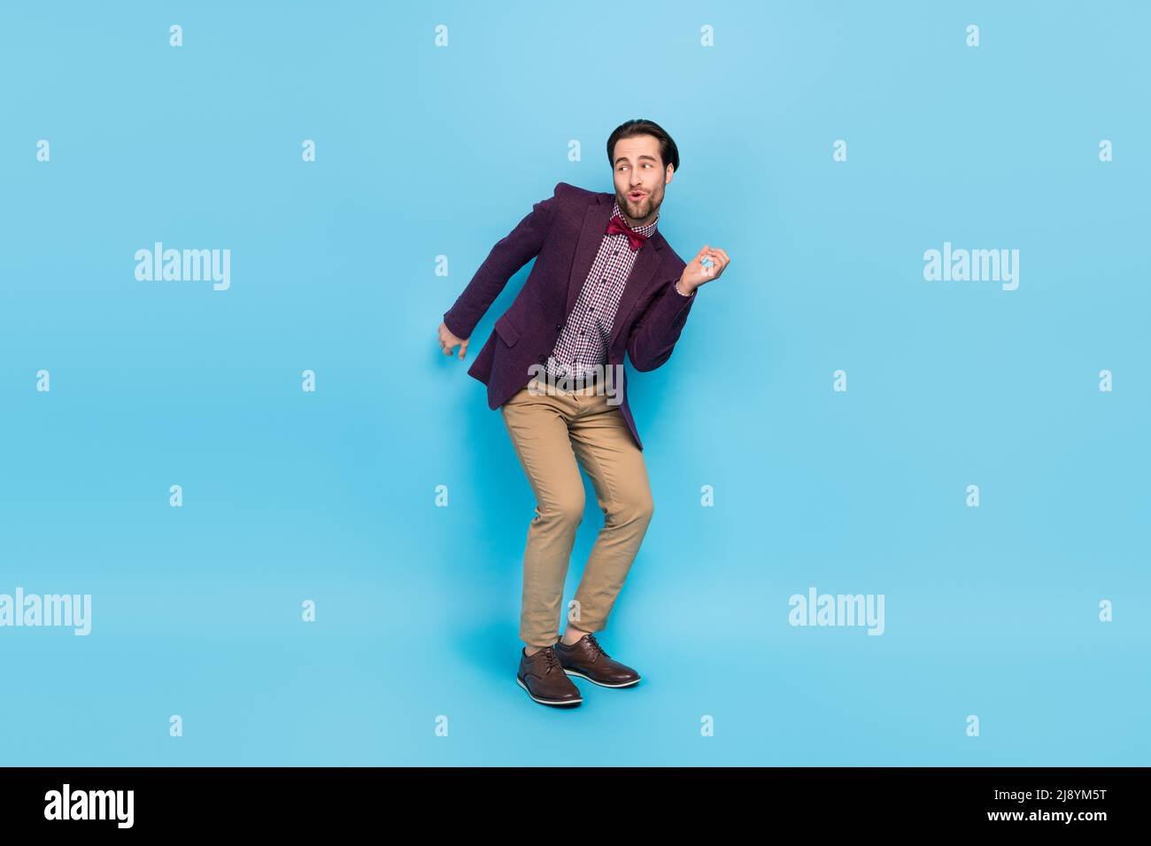 Ganzkörper-Foto von jungen aufgeregt Mann chill-Hang-out festlichen Look leeren Raum isoliert über blauen Hintergrund Stockfoto
