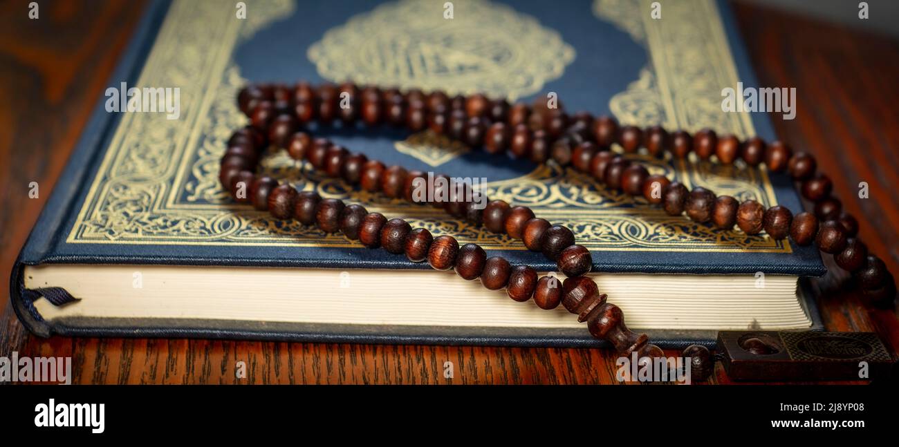 Hintergrundtapete von Rosenkranz Perlen (tasbih) und dem heiligen Koran Koran Koran Stockfoto