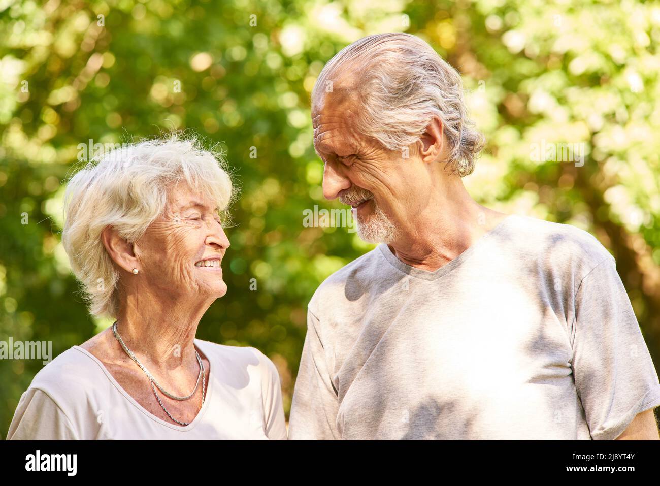 Glückliches Rentnerpaar, das im Sommer einen Spaziergang im Park macht Stockfoto