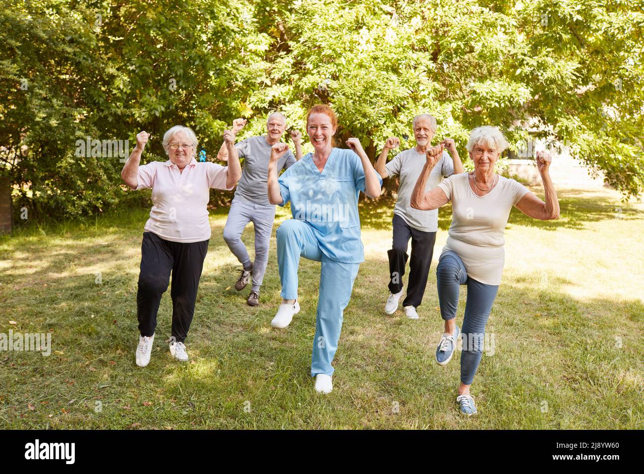 Gruppe von energetischen Senioren, die Aerobic in einem Fitnesskurs als Ausdauertraining im Alter machen Stockfoto