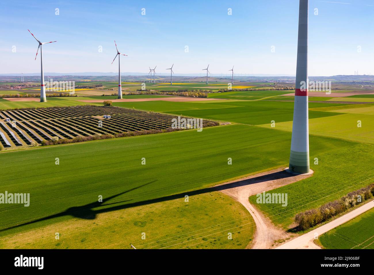 Luftaufnahme von Windturbinen und Sonnenkollektoren eines Solarparks zwischen Feldern in Rheinland-Pfalz, Deutschland Stockfoto