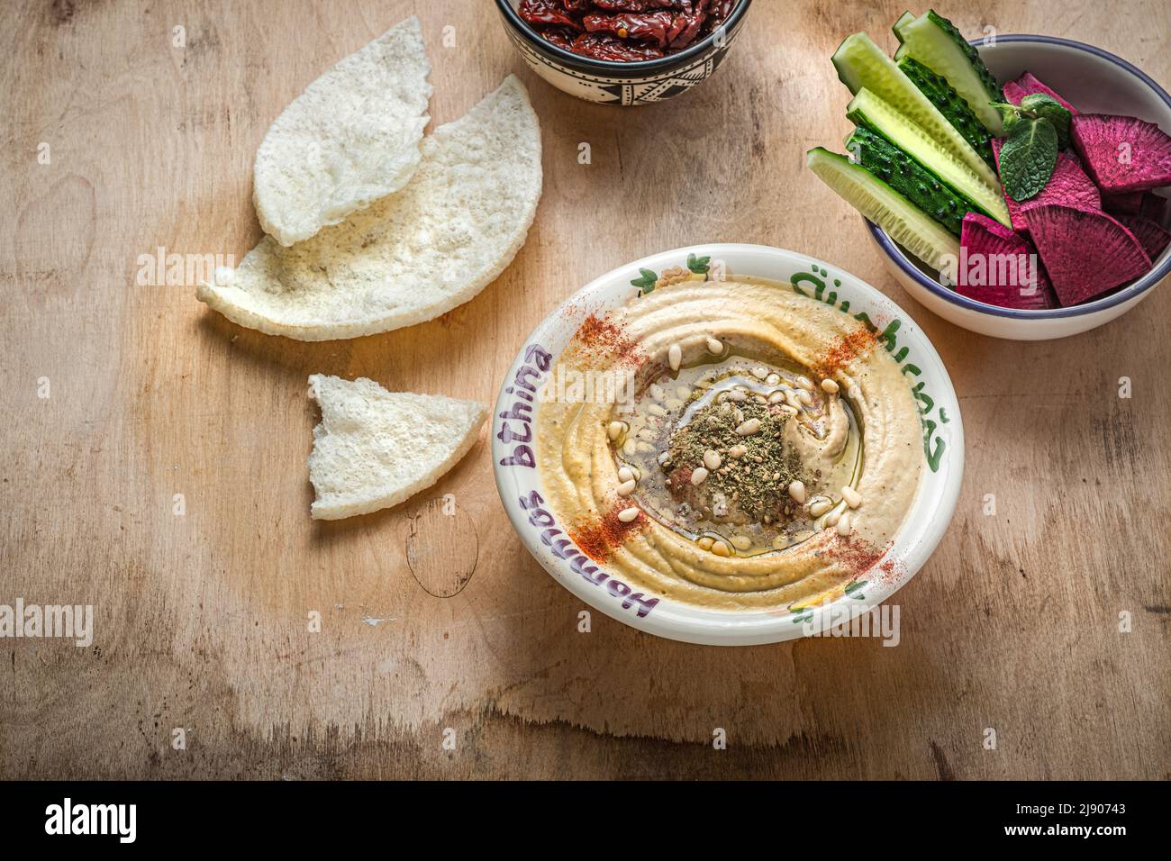 Kichererbsen-Hummus mit Olivenöl und geräuchertem Paprika mit Gurke und Rettich Stockfoto