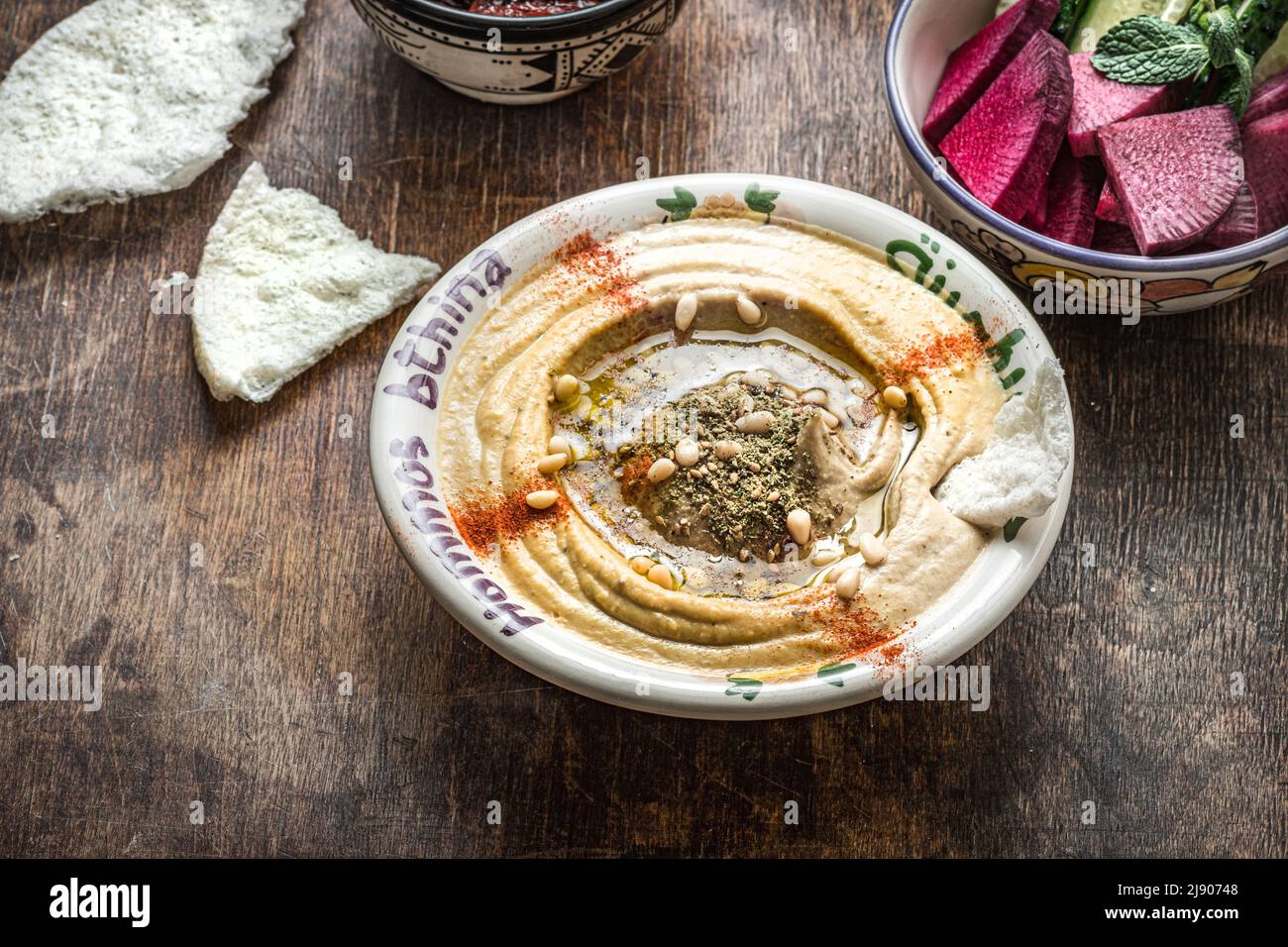 Kichererbsen-Hummus mit Olivenöl und geräuchertem Paprika mit Gurke und Rettich Stockfoto
