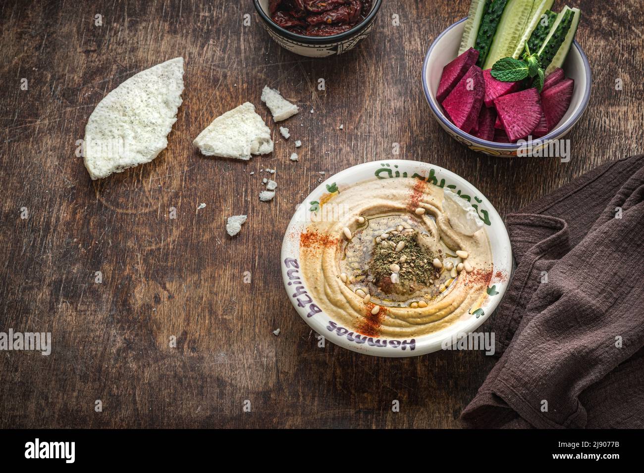 Kichererbsen-Hummus mit Olivenöl und geräuchertem Paprika mit Gurke und Rettich Stockfoto