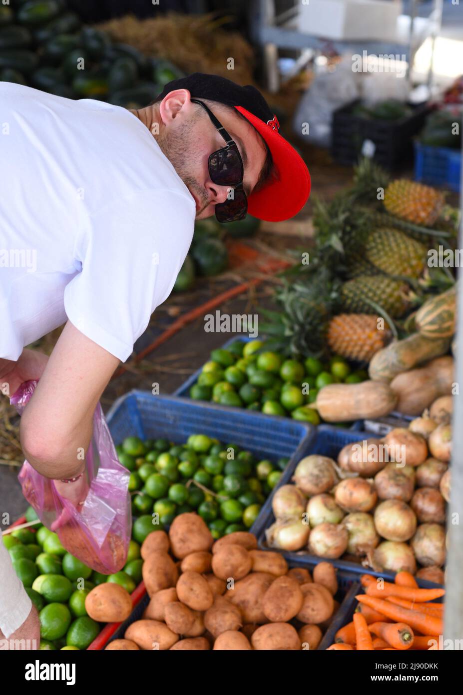 Junger Mann, der Gemüse auf dem vietnamesischen Markt wählt Vinh Hai Nha Trang Stockfoto