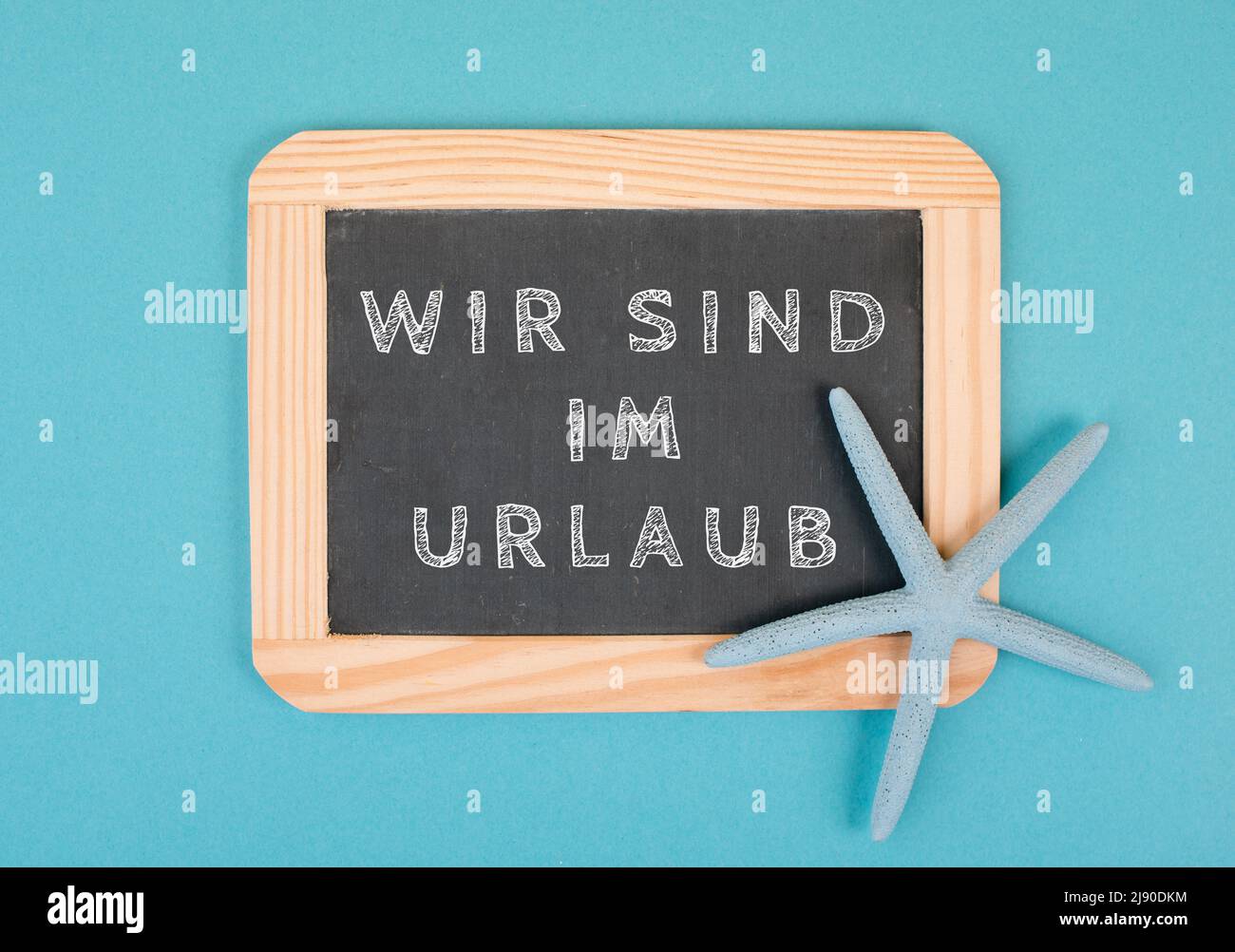 Wir sind im Urlaub steht in deutscher Sprache auf der Tafel mit einem