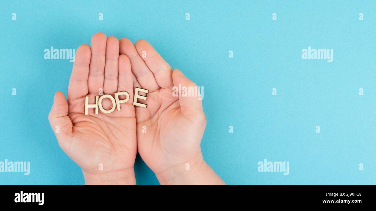 Das Wort Hoffnung in den Händen halten, Vertrauen und glauben Konzept, Vertrauen in die Zukunft haben, hoffnungsvoll positive Denkweise Stockfoto