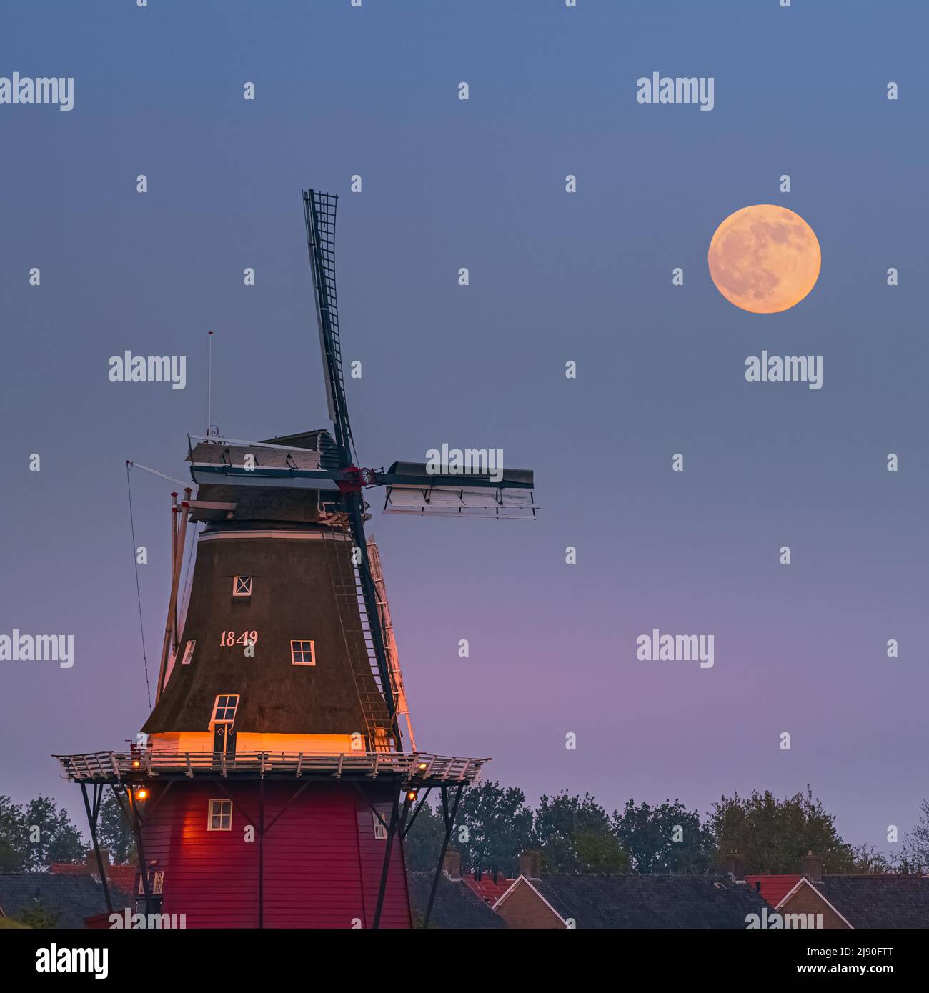 Ein quadratisches Bild von Sonnenuntergang und Mondaufgang mit einem Vollmond in der Nähe der Mehlmühle 'De Hoop' in der niederländischen Stadt Dokkum, in der Provinz Friesland im No Stockfoto