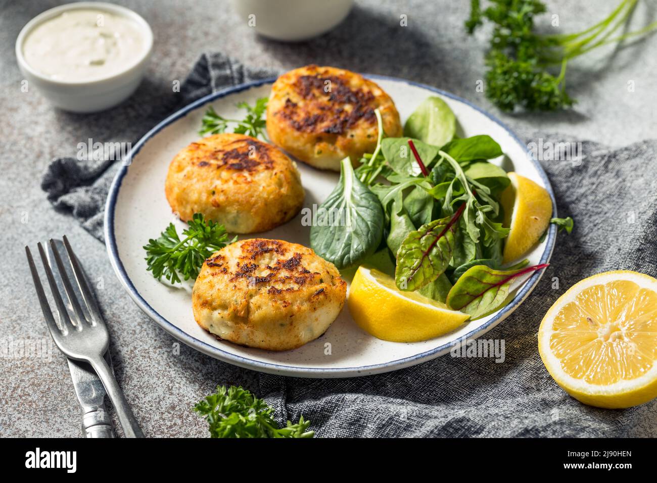 Hausgemachte gebratene Krabbenkuchen mit Salat und Tatarensauce Stockfoto