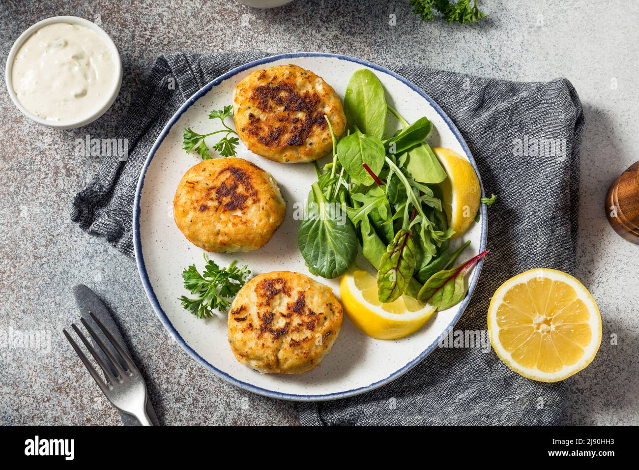 Hausgemachte gebratene Krabbenkuchen mit Salat und Tatarensauce Stockfoto