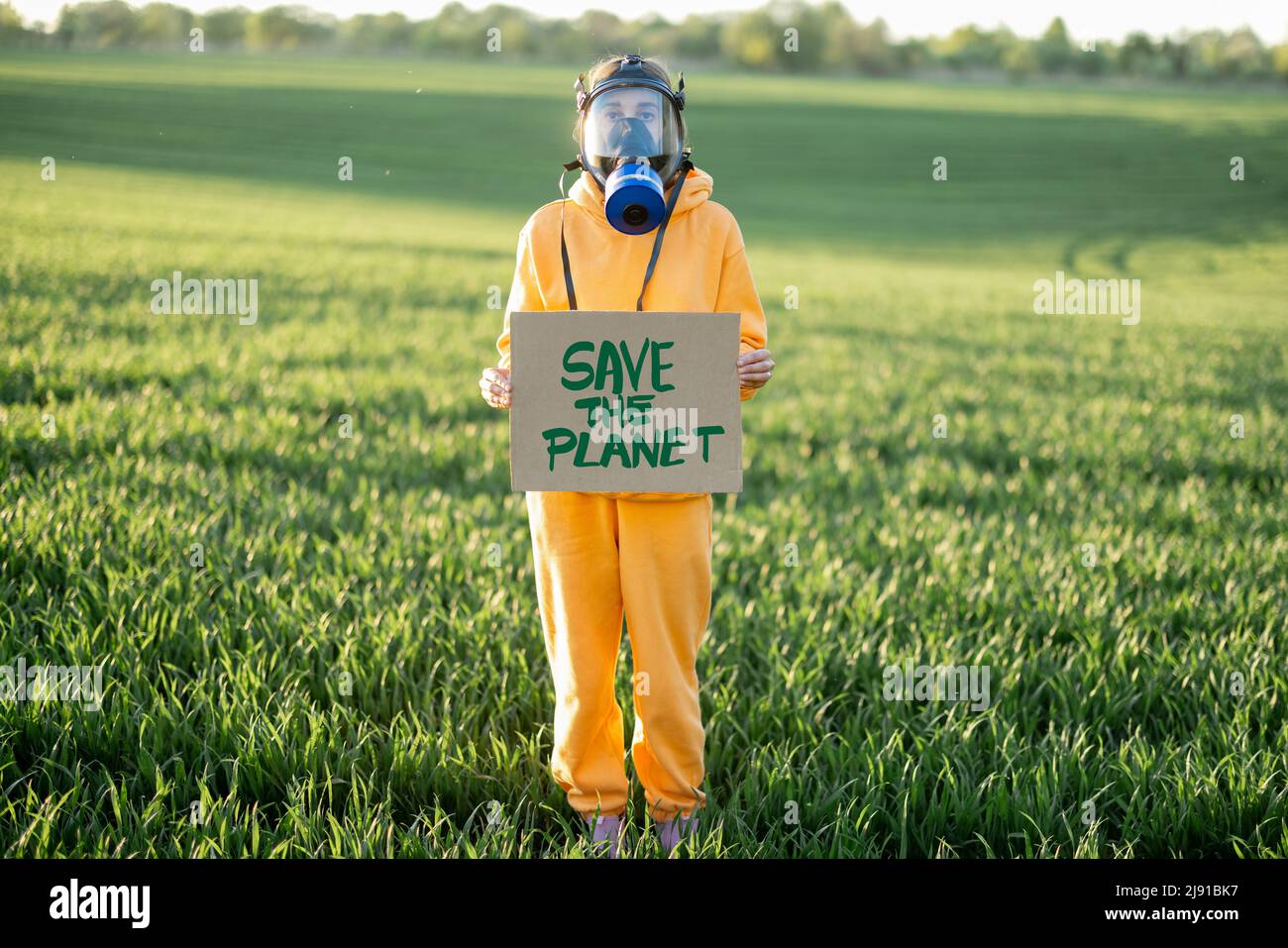 Person in Gasmaske hält Pappe mit einem Aufruf, den Planeten zu retten Stockfoto