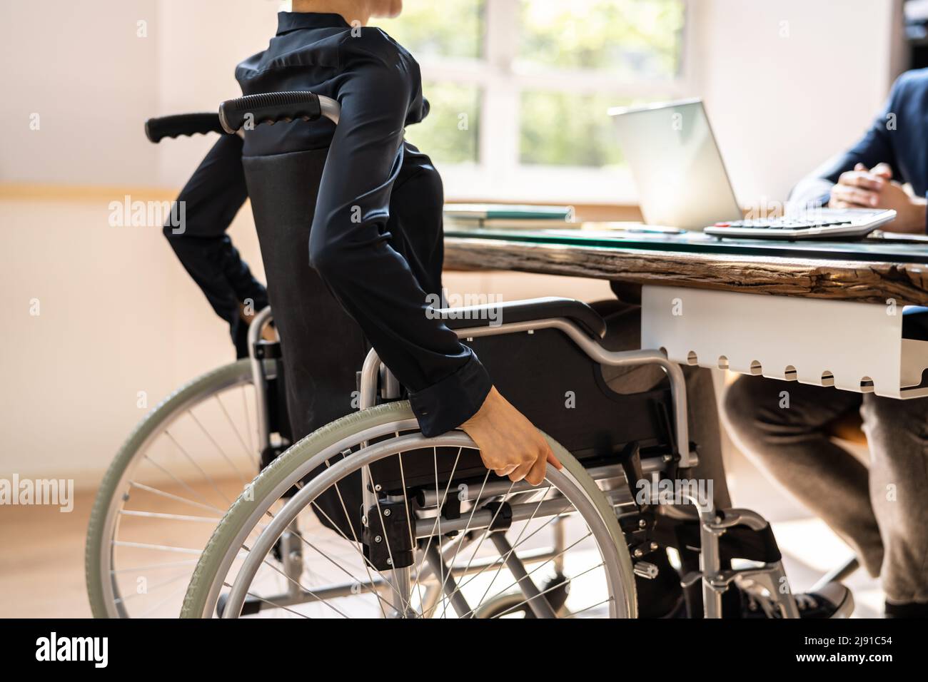 Geschäftsfrau Mit Behinderungen, Die Im Büro Im Rollstuhl Sitzt Stockfoto