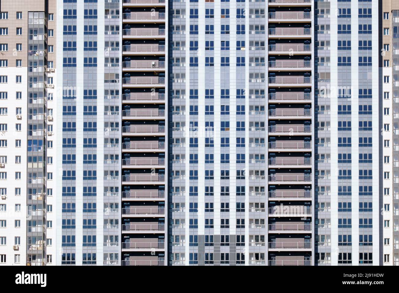Helle Fassade eines Wohngebäudes. Abstrakter Hintergrund von Fenstern. Stockfoto