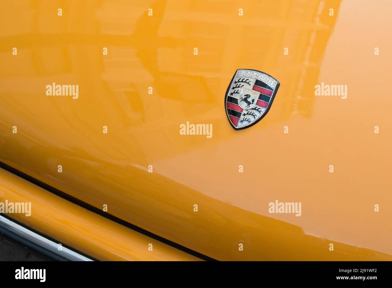 Madrid, Spanien; 04172022: Nahaufnahme eines leuchtend orangen porsche, der auf der Straße geparkt ist. Vorderteil. Stockfoto