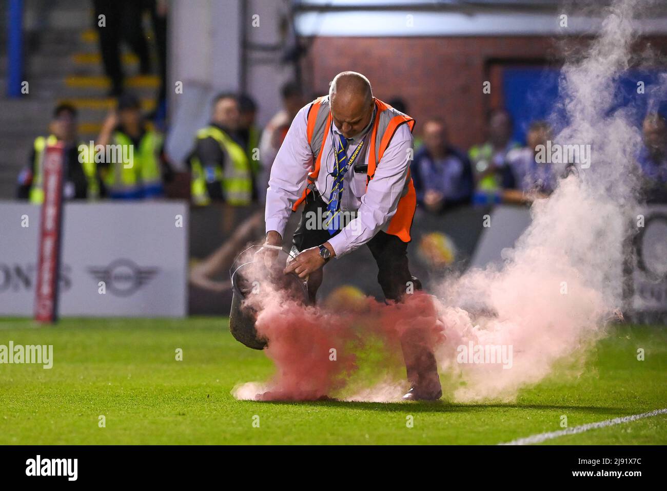 Ein Steward befasst sich mit einem Flare, der vom Stand auf den Platz geworfen wurde Stockfoto