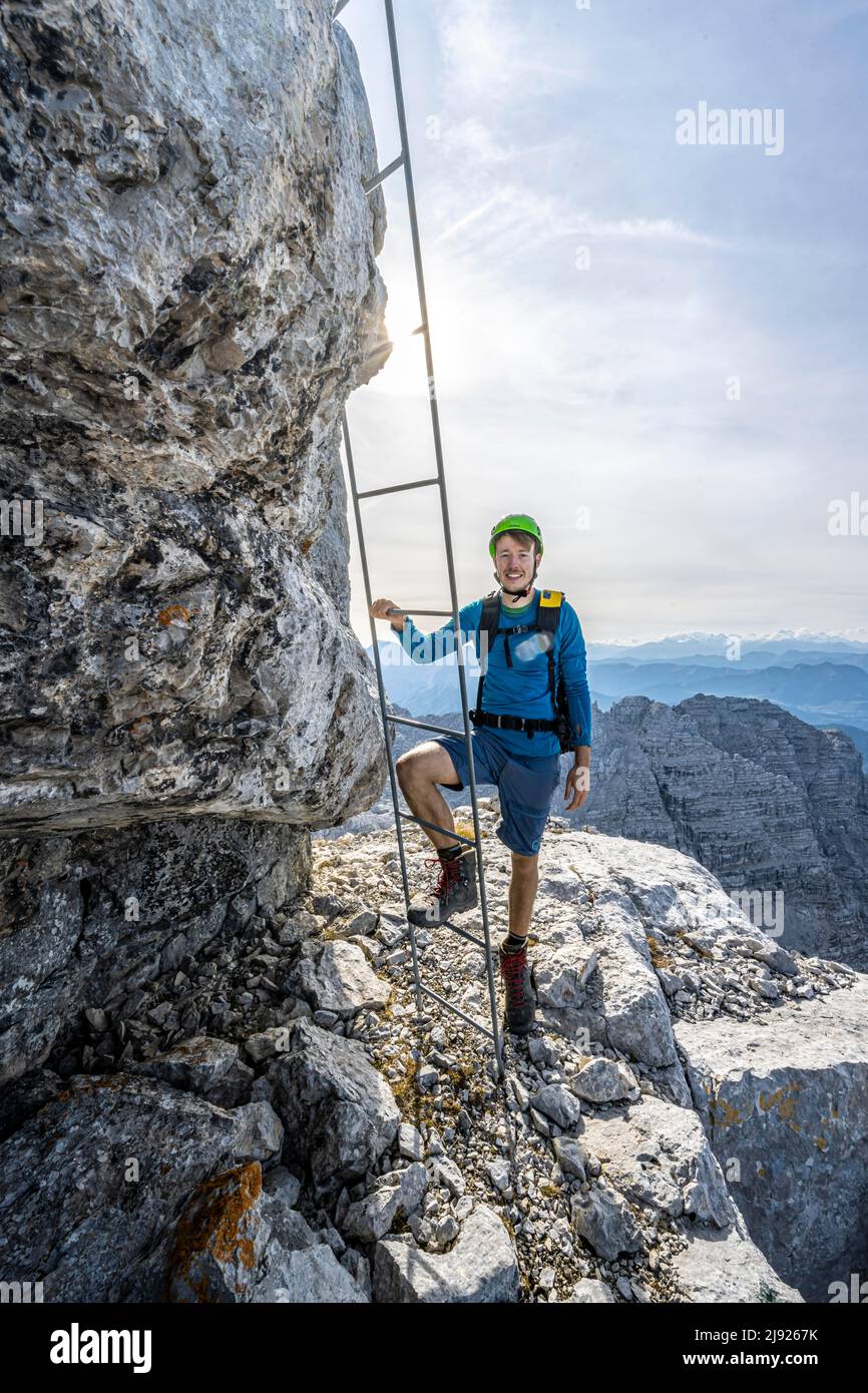 Wanderer auf einem gesicherten Weg, über eine Leiter, Aufstieg zum Mitterhorn, steile felsige Berglandschaft, Nuaracher Höhenweg, Loferer Steinberge, Tirol Stockfoto