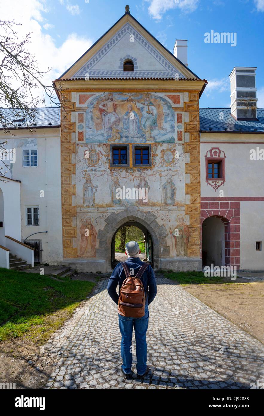 Mann, der vor dem Haupttor mit Fresken steht, Zisterzienserabtei von Vyssi Brod, Vyssi Brod an der Moldau, Hohenfurth, Sumava, Süden Stockfoto