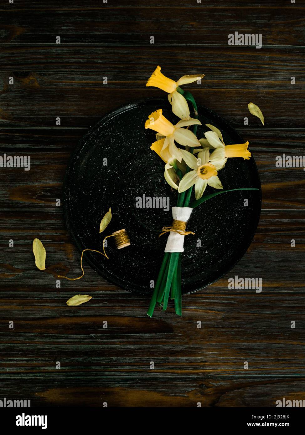 Daffodil-Bouquet auf einem Holztisch in stimmungsvoller Beleuchtung angeordnet Stockfoto