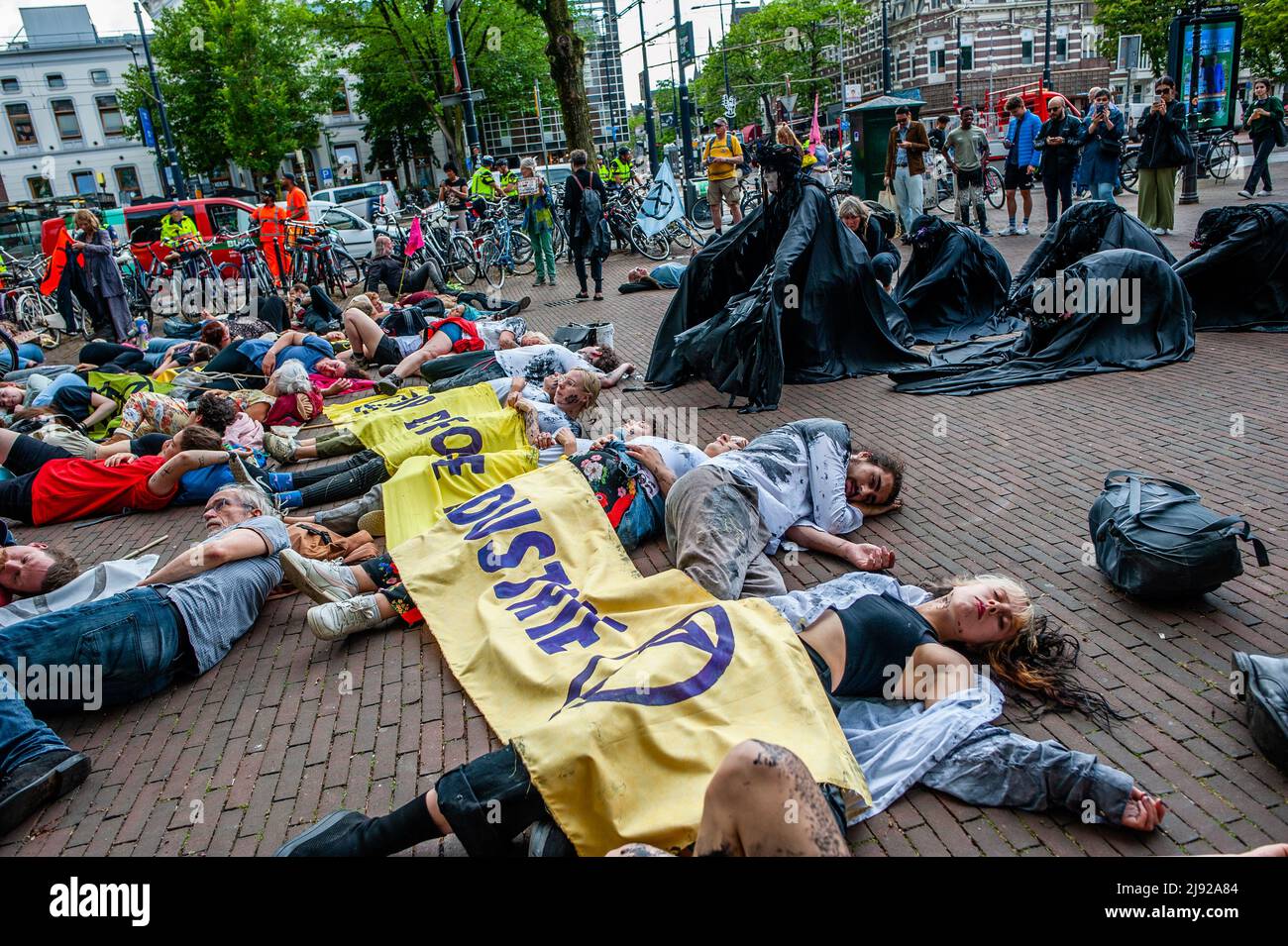 Rotterdam, Niederlande, 19/05/2022, die Schwarzen Rebellen (Menschen in schwarzer Kleidung) werden während der Demonstration gesehen, wie sie die Aktivisten auf dem Boden liegen sehen. Mit diesem Protest startete die Klimaorganisation Extinction Rebellion (XR) eine Kampagne, um ein Ende der fossilen Industrie und einen klimafreundigen Übergang zu fordern. Hunderte von Aktivisten versammelten sich am Hauptbahnhof von Rotterdam und marschierten von dort aus durch die Stadt, darunter mehrere künstlerische Darbietungen. Diese Kampagne wird bis zum 24.. Mai andauern und auf mehrere disruptive Aktionen und Workshops zählen, um Emerg zu fordern Stockfoto