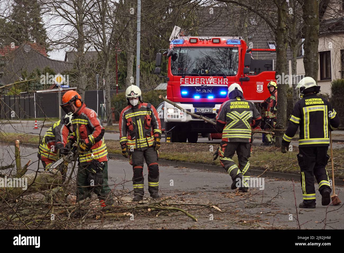 18.02.2022, Neuenhagen, Brandenburg, Deutschland - Feuerwehrleute räumen nach dem Sturm Ylenia einen umgestürzten Baum von der Straße in der Lindenstraße. 00S220218D304CARO Stockfoto