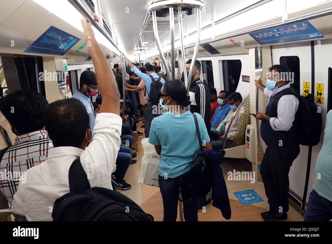 22.02.2022, Doha, , Katar - Frau, die in Zeiten der Corona-Pandemie in der U-Bahn im Männerfach reitet. 00S220222D341CAROEX.JPG [MODELLVERSION: NEIN, EIGENTUM Stockfoto