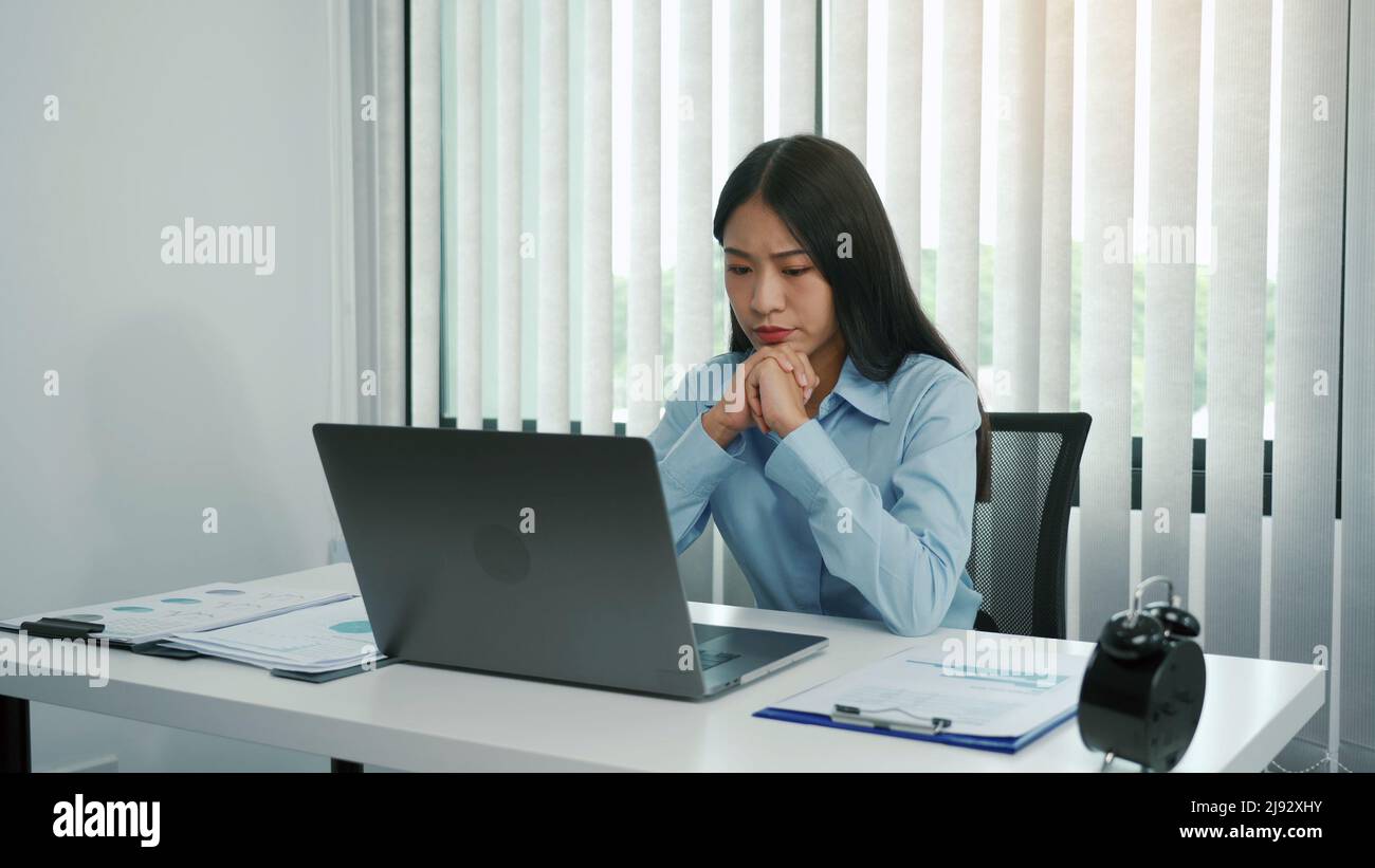 Junge asiatische Frauen sind besorgt oder gestresst über die Arbeit im Unternehmensbüro. Stockfoto