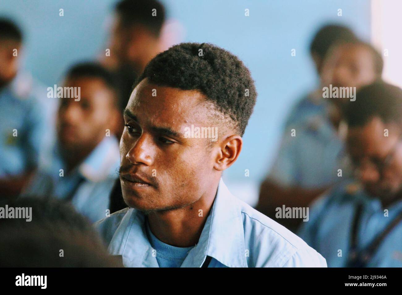 Ein Schüler der De La Salle Secondary School in Bomana in Port Moresby, Papua-Neuguinea, der DHERST-Mitarbeitern während eines Schulbesuchs im August 2018 zuhört Stockfoto